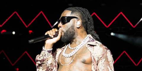 Burna Boy was seen wearing black Saint Laurent Sun Blaze SL M119 001 butterfly sunglasses at the Afro Nation Miami 2023 in Miami, Florida