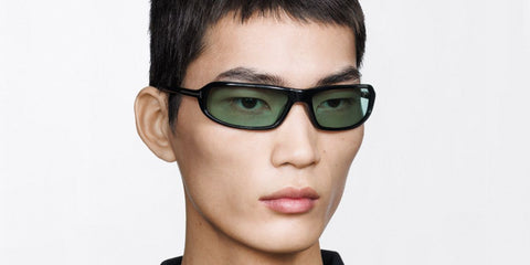 Male model wears Tom Ford Addison-02 TF1400 01N black wraparound sunglasses with green lenses