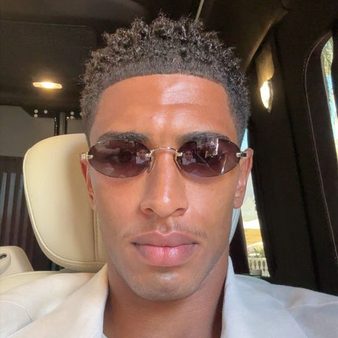Jude Bellingham was seen wearing gold Miu Miu MU A54S 5AK20I oval sunglasses with purple brown lenses in his Instagram post, May 2026