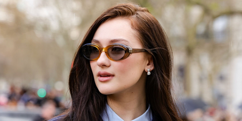 The Summer I Turned Pretty actress Lola Tung was seen wearing transparent yellow beige Miu Miu MU B09S 24M50Q Reverie oval sunglasses with grey lenses at the Miu Miu Fall/Winter 2026 fashion show during Paris Fashion Week.