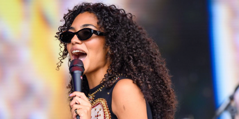 British singer Olivia Dean was seen wearing black Prada PR 26ZS 16K08Z cat eye sunglasses onstage at the Glastonbury Festival 2024. Shop online now on Pretavoir
