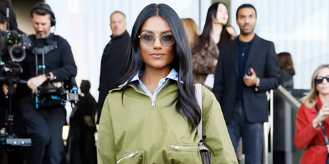 Simone Ashley was seen wearing pale gold Prada PR 65ZS ZVN70L round sunglasses with green lenses to attend the Prada Fall/Winter 2025 fashion show during Milan Fashion Week